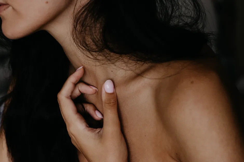 Nude naglar i rosa nyans på en hand mot ljus bakgrund